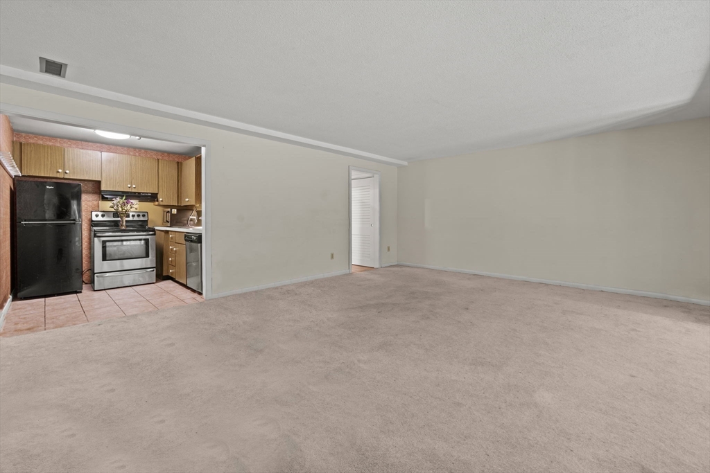 374 Great Road, Unit 11 Acton, MA 01720 - Photo 16 of 30 a view of a kitchen with a stove fridge and wooden floor