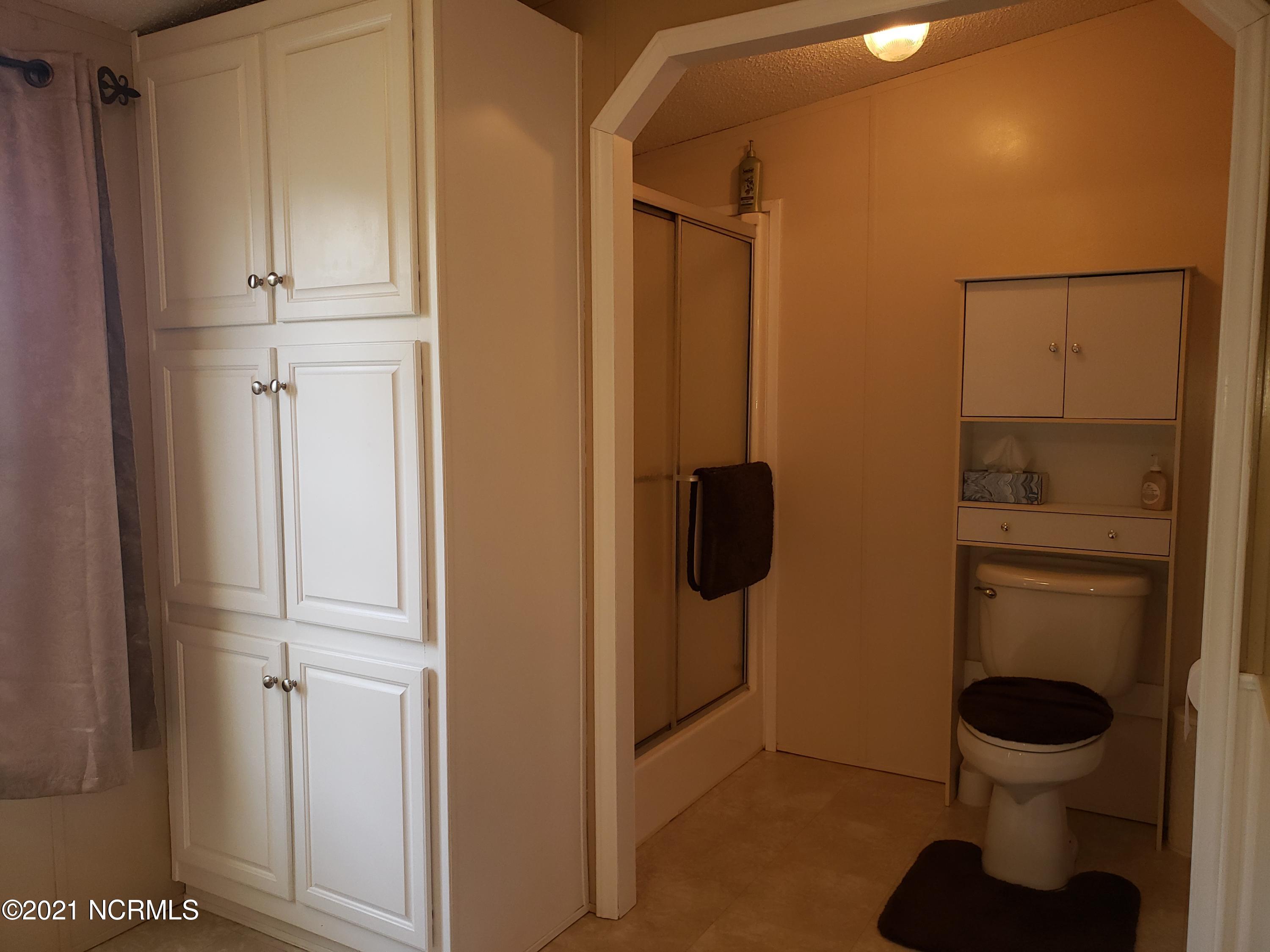 2459 Stout Road Northwest Ash, NC 28420 - Photo 8 of 19 Owners bathroom has soaking tub, walk-in shower and a linen cabinet.