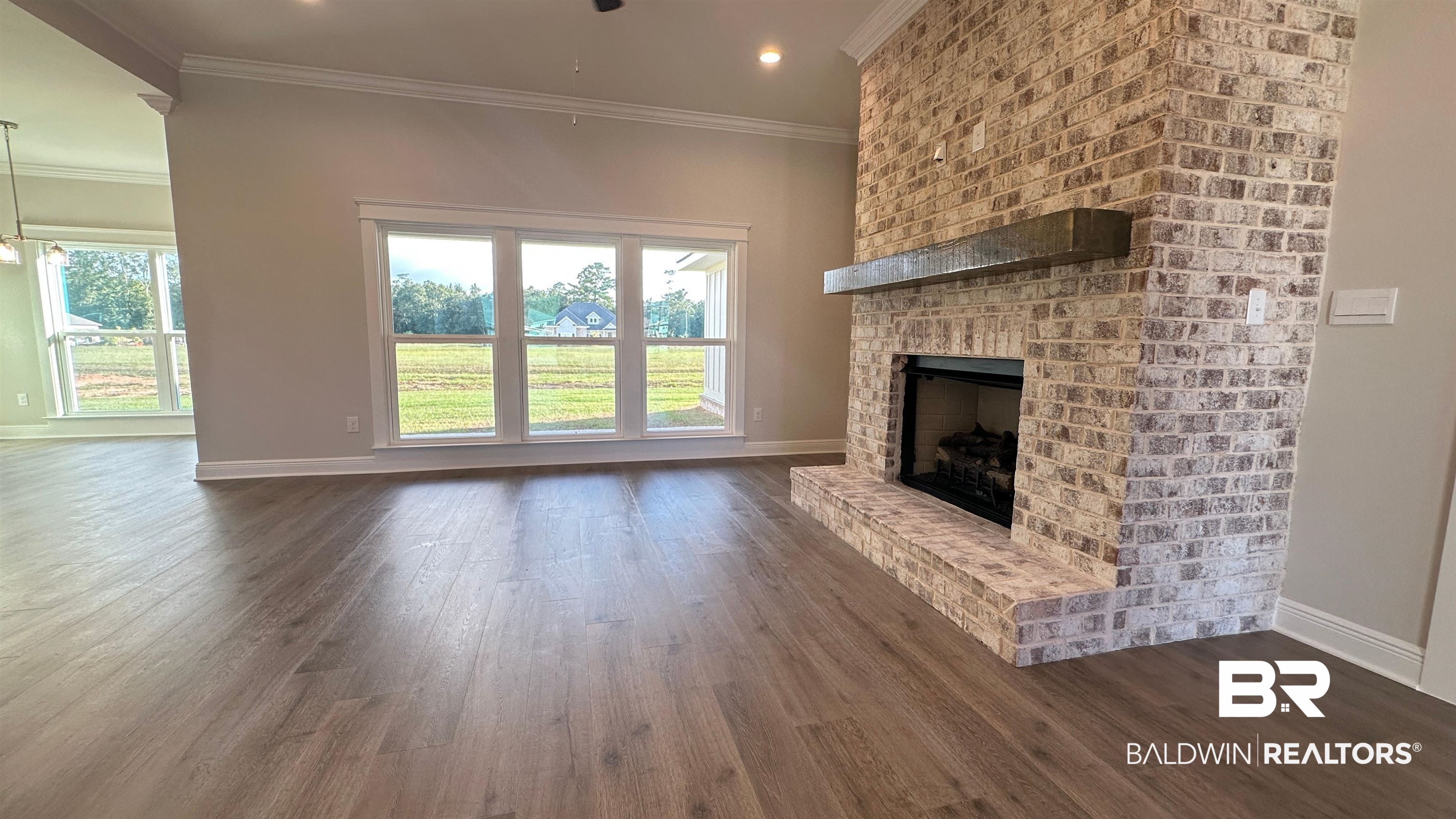 126 Daybreak Trail Fairhope, AL 36532 - Photo 6 of 34 Unfurnished living room featuring ornamental molding, a fireplace, dark wood-style floors, and recessed lighting