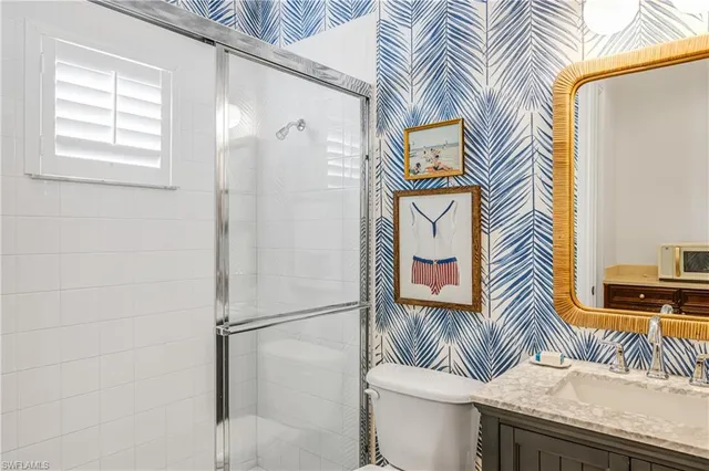 a bathroom with a granite countertop toilet sink and mirror