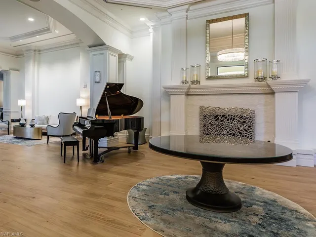a living room with furniture a piano and a fireplace