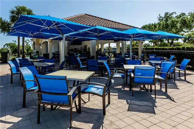 a view of a patio with a table and chairs under an umbrella