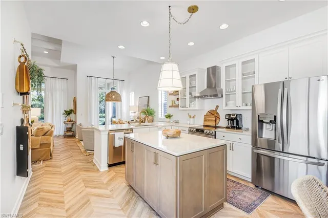 a kitchen that has a lot of white cabinets and stainless steel appliances