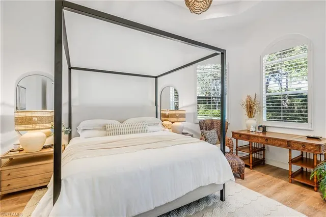 a bedroom with a bed and a dresser next to a window