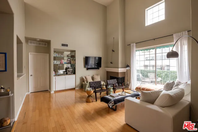 a living room with furniture floor to ceiling window and a flat screen tv