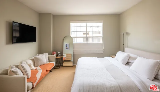 a bedroom with a bed and a flat screen tv