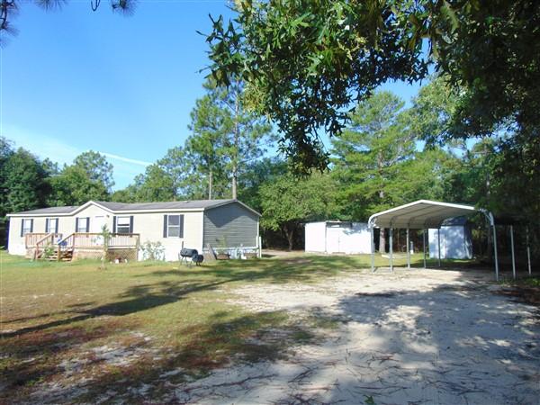 1051 Hinote Road DeFuniak Springs, FL 32433 - Photo 1 of 39 a swimming pool with outdoor seating and yard