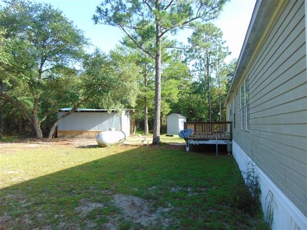 1051 Hinote Road DeFuniak Springs, FL 32433 - Photo 22 of 39 a view of a chair and table in backyard of the house