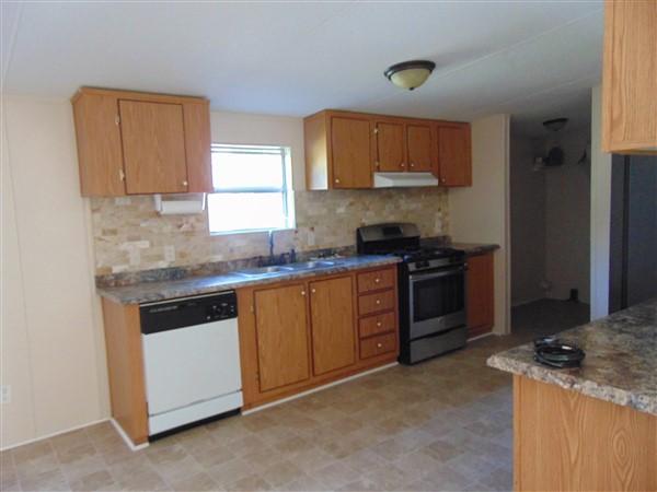 1051 Hinote Road DeFuniak Springs, FL 32433 - Photo 27 of 39 a kitchen with granite countertop a sink stove and cabinets