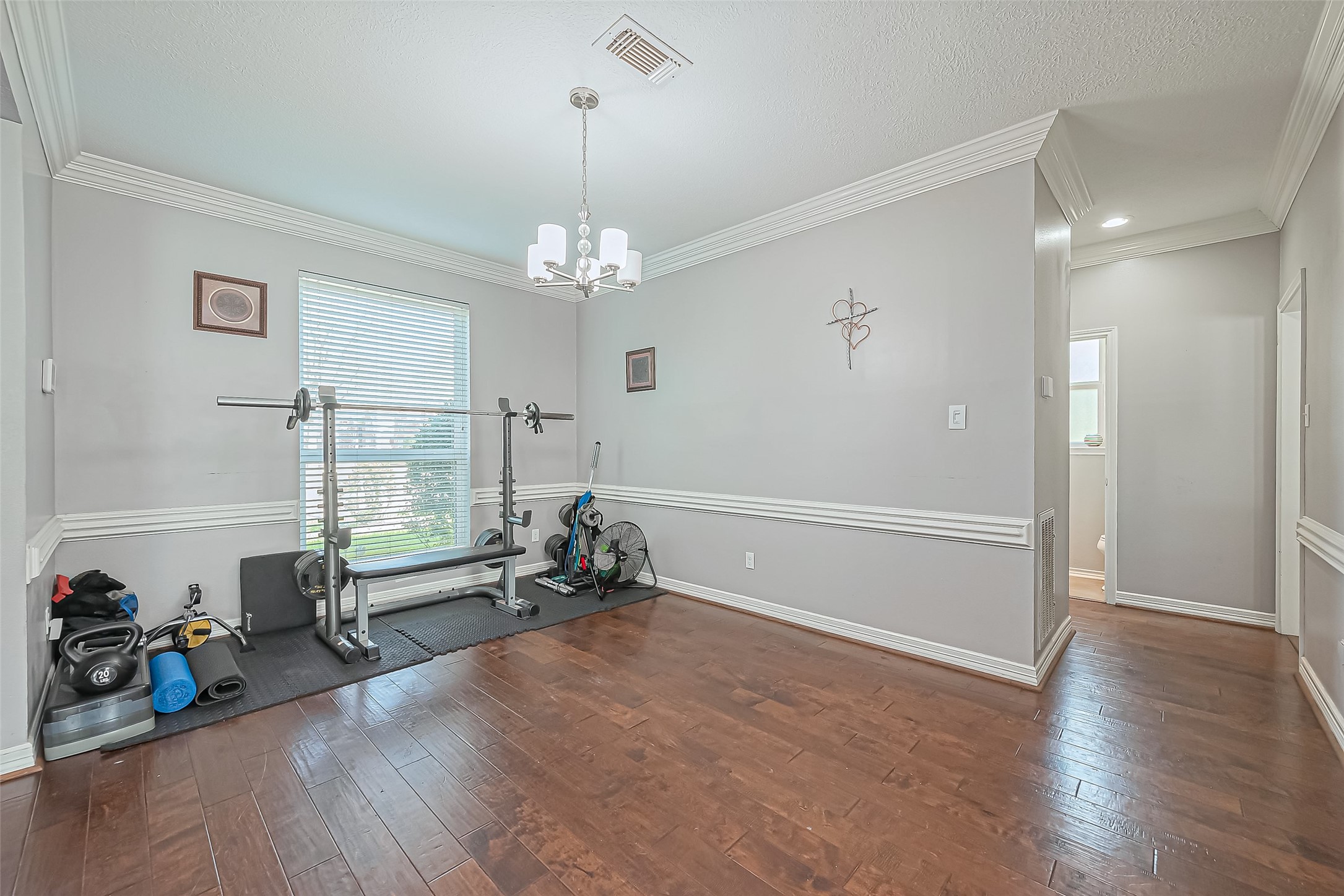 5803 Slashwood Lane Spring, TX 77379 - Photo 11 of 46 Versatile formal dining room currently set up as a home gym, offering flexible space for your lifestyle needs.