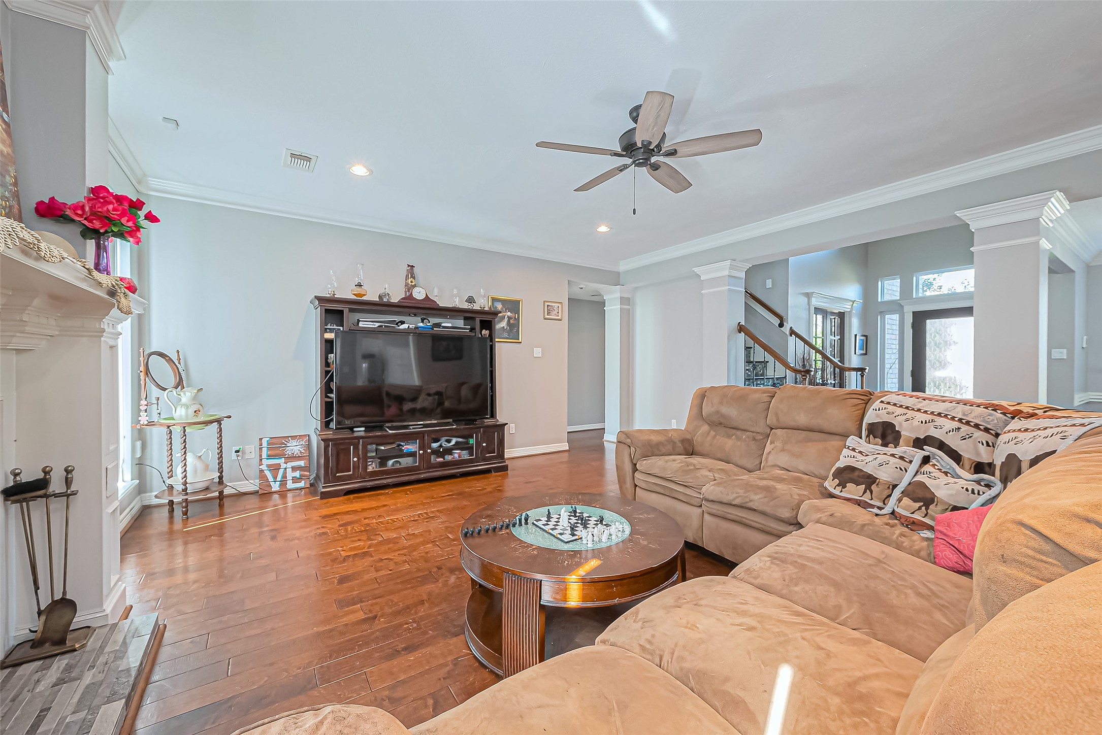 5803 Slashwood Lane Spring, TX 77379 - Photo 13 of 46 Spacious and inviting living room with engineered wood floors, abundant natural light, and a cozy fireplace, perfect for relaxation and entertainment.