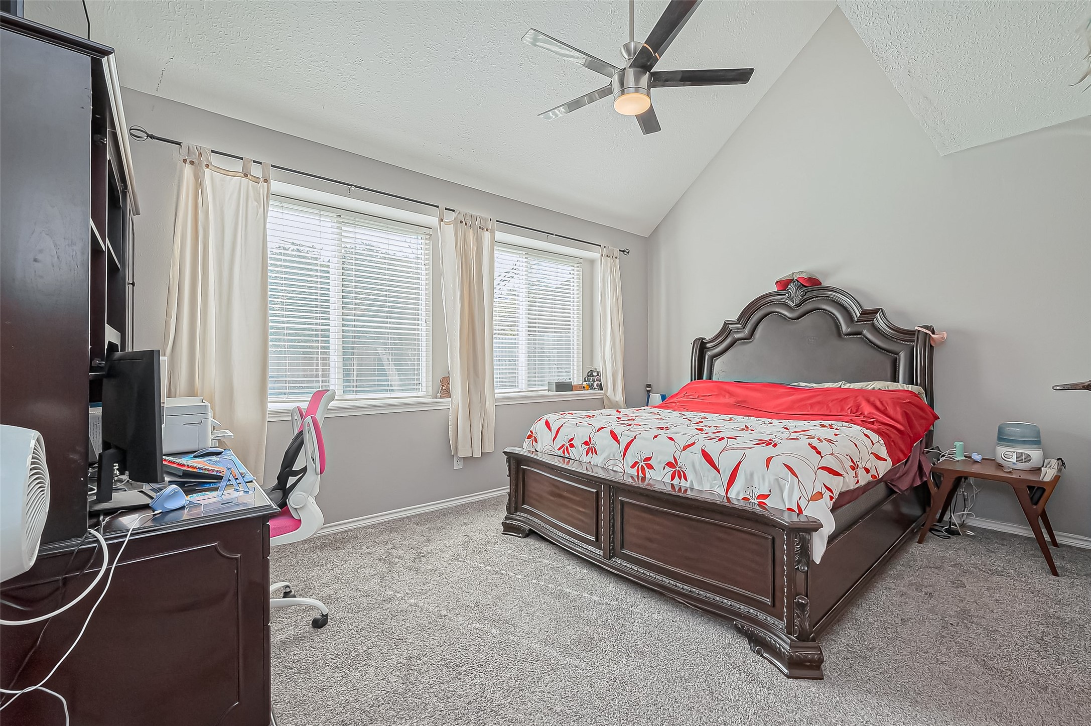 5803 Slashwood Lane Spring, TX 77379 - Photo 35 of 46 Spacious primary bedroom featuring vaulted ceilings, abundant natural light, and plush carpeting for ultimate comfort.