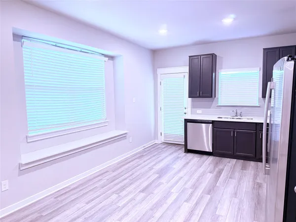 a view of kitchen with stainless steel appliances granite countertop a stove a sink and a refrigerator