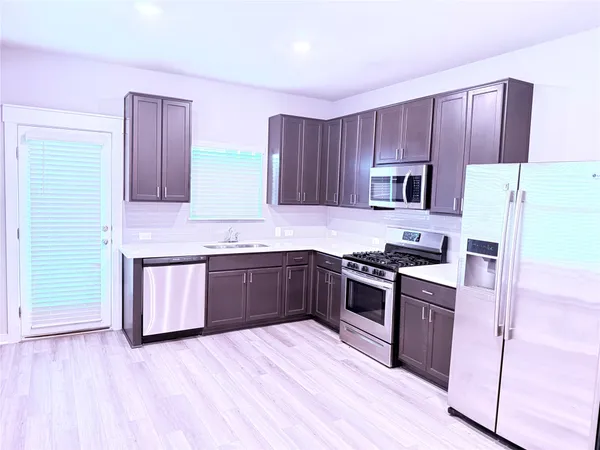 a kitchen with a sink stove top oven and cabinets