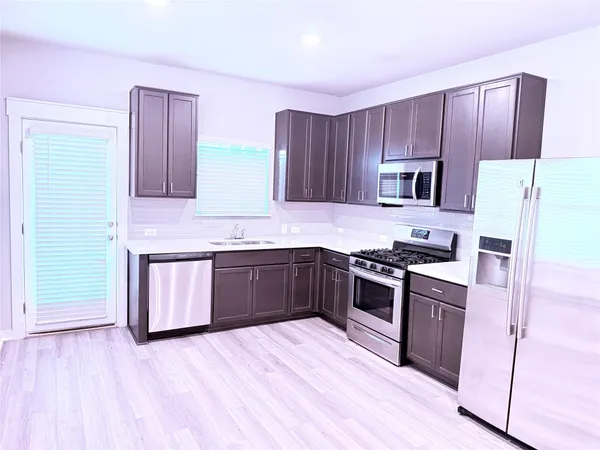 a kitchen with a sink stove top oven and refrigerator