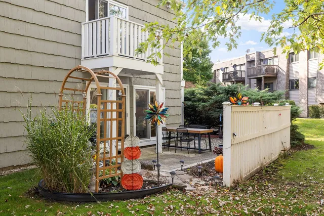 a view of a house with potted plants and a bench