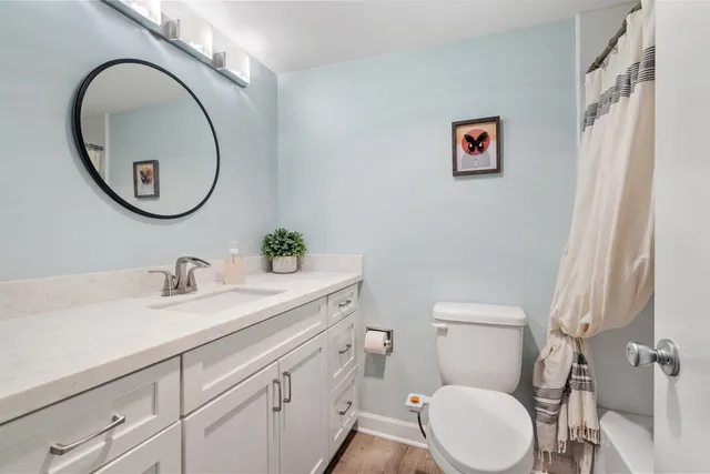 a bathroom with a toilet a sink and a mirror