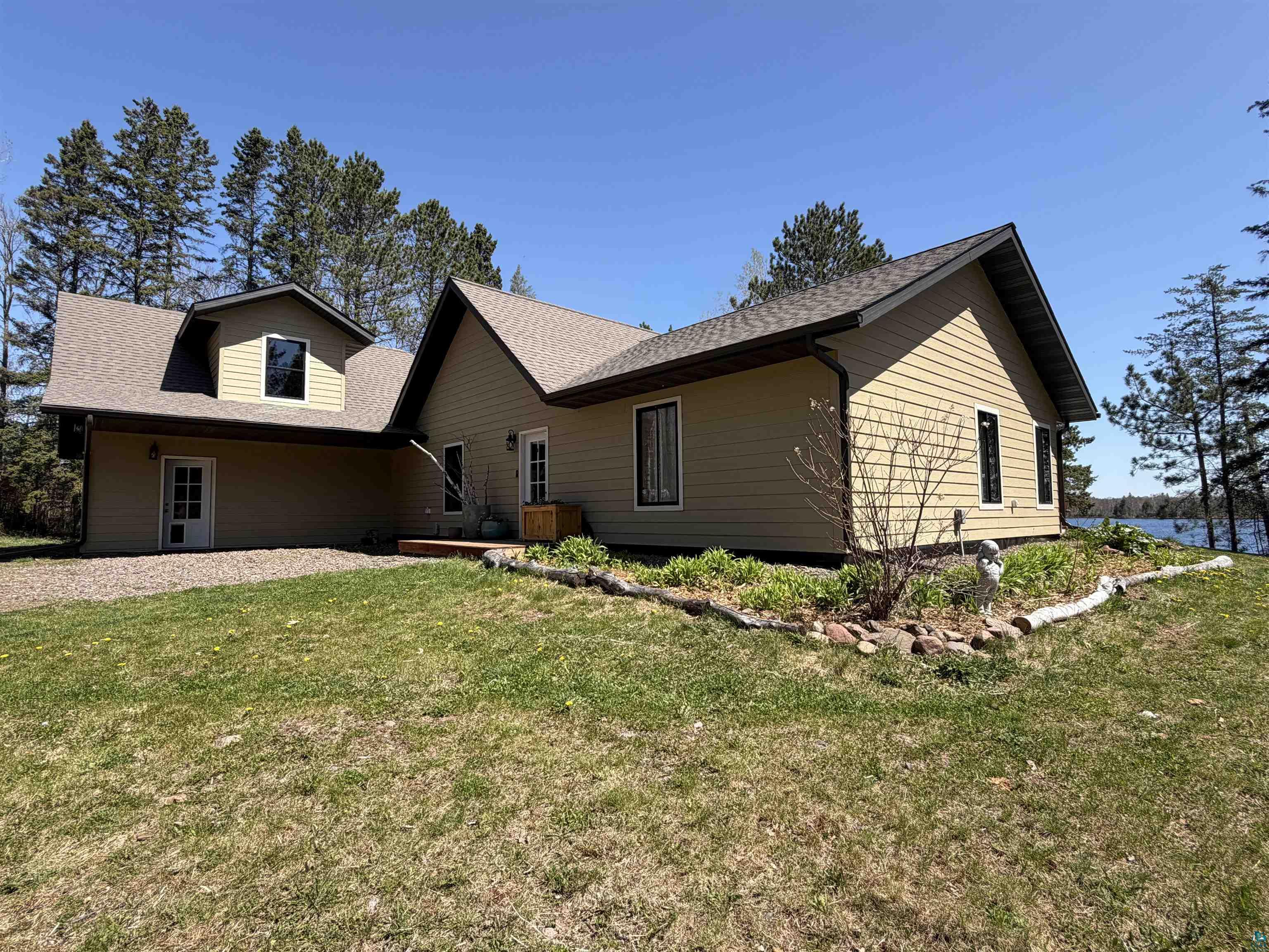 5274 Marble Lake Road Two Harbors, MN 55616 - Photo 63 of 79 Two-story exterior with light beige siding, dark-frame windows, and a multi-pitch roof