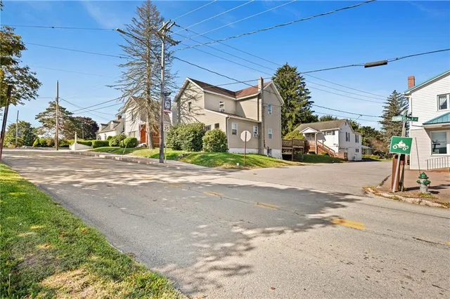 a front view of a house with a yard and trees