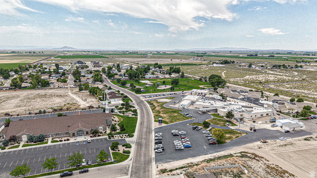 84 White Sage Avenue, Unit 2 Delta, UT 84624 - Photo 15 of 18 Aerial landscape featuring a developed community with residential areas, a large building with a brown roof and steeple, and a complex of commercial/institutional buildings with white roofs