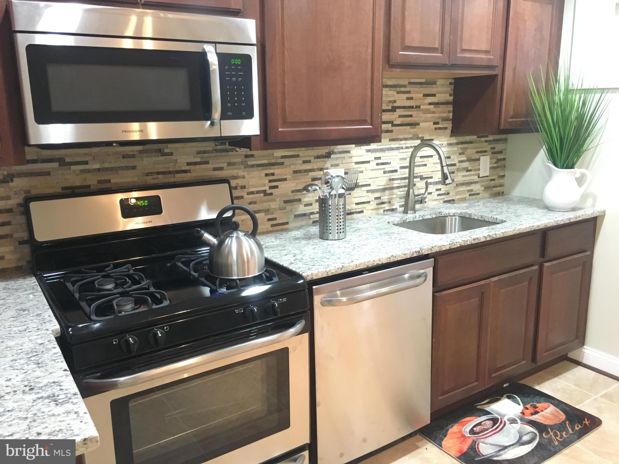8030 Gray Haven Road Baltimore, MD 21222 - Photo 12 of 30 a kitchen with stainless steel appliances granite countertop a stove microwave and sink