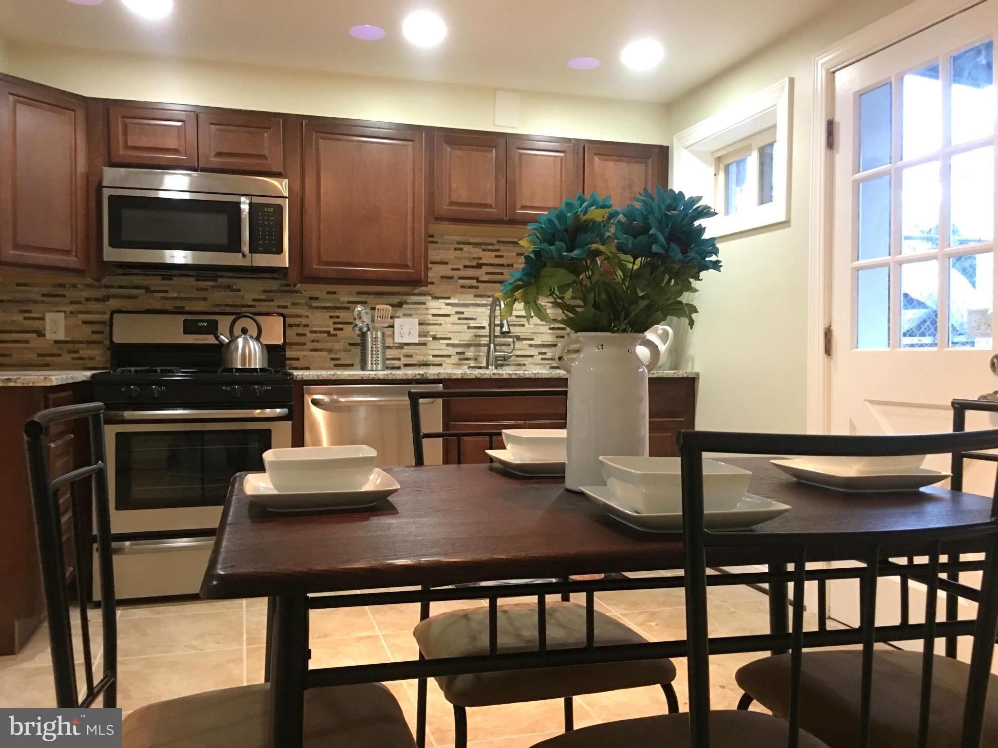 8030 Gray Haven Road Baltimore, MD 21222 - Photo 8 of 30 a kitchen with a table chairs microwave and refrigerator