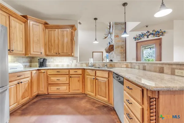 a kitchen with granite countertop a sink stainless steel appliances and cabinets