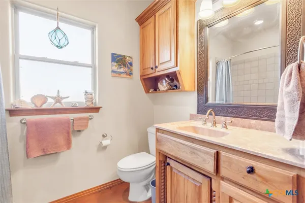 a bathroom with a sink a toilet and mirror
