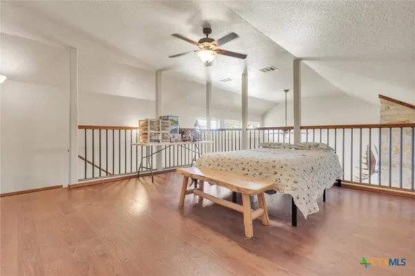 a room with wooden floor pool table and chairs