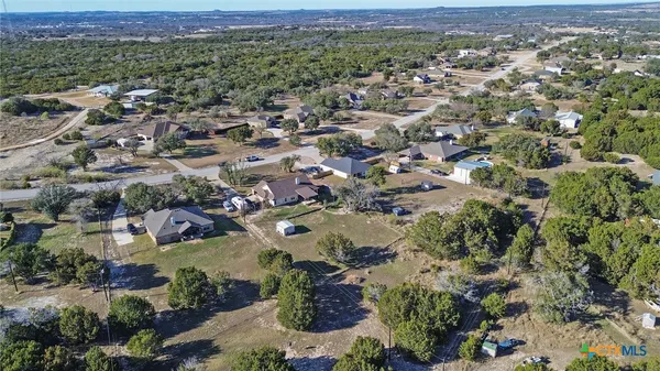 an aerial view of residential houses with outdoor space and trees
