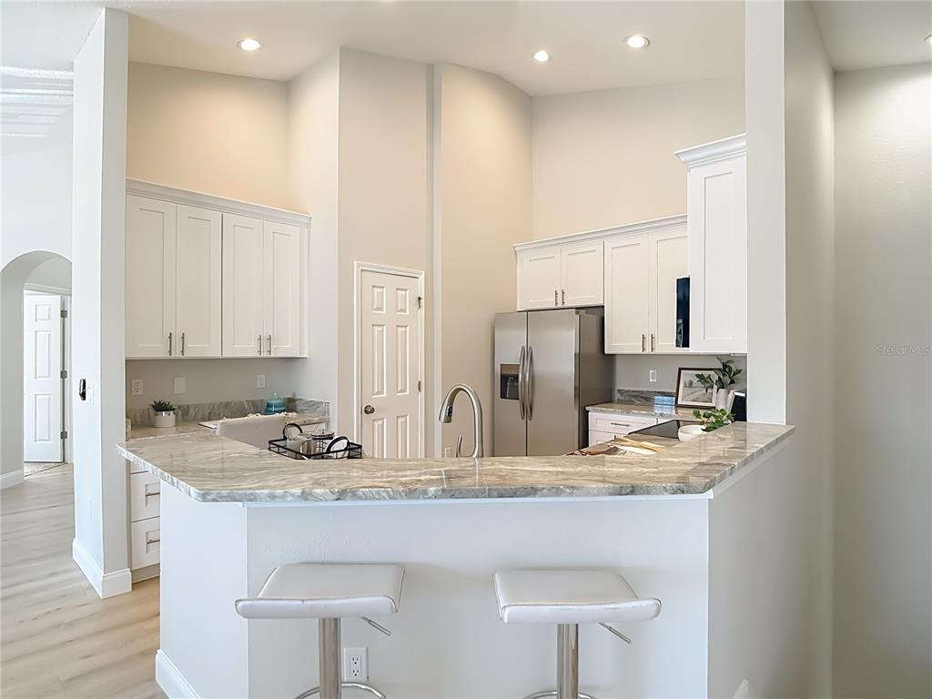 5310 Anhinga Trail New Port Richey, FL 34653 - Photo 11 of 27 a kitchen with kitchen island granite countertop a sink and cabinets