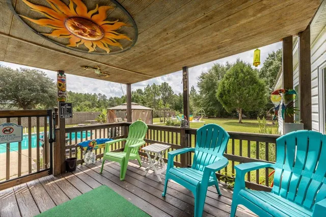 a view of a swimming pool with lawn chairs and a big yard