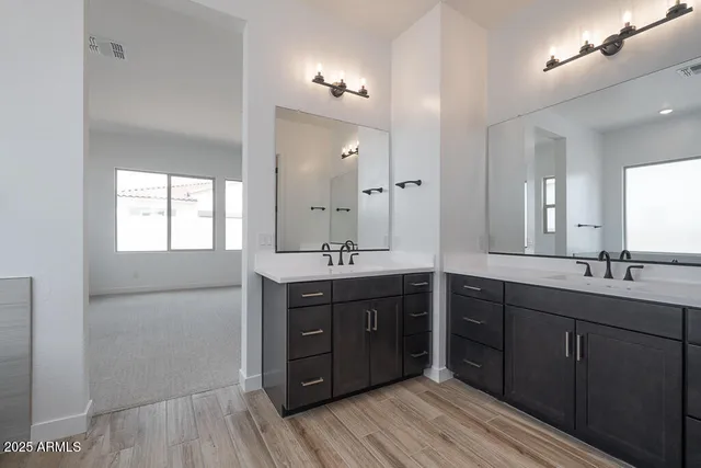 a spacious bathroom with a double vanity sink and mirror