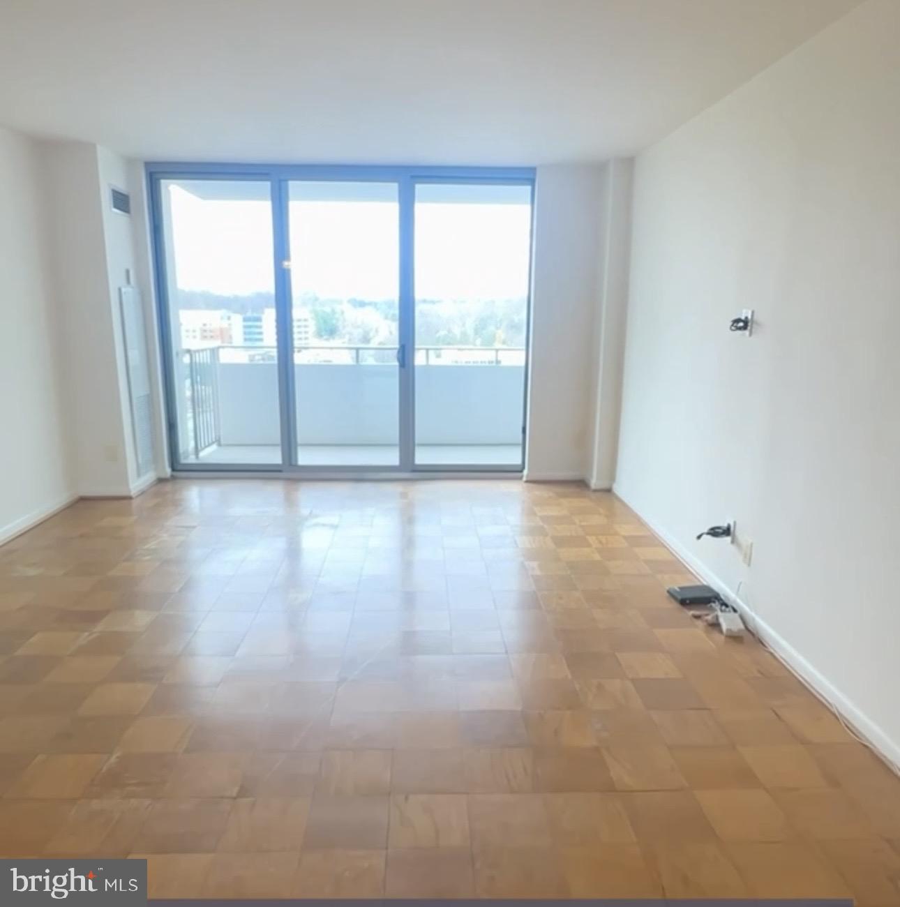 5101 River Road, Unit 1103 Bethesda, MD 20816 - Photo 2 of 22 a view of an empty room with wooden floor and a window