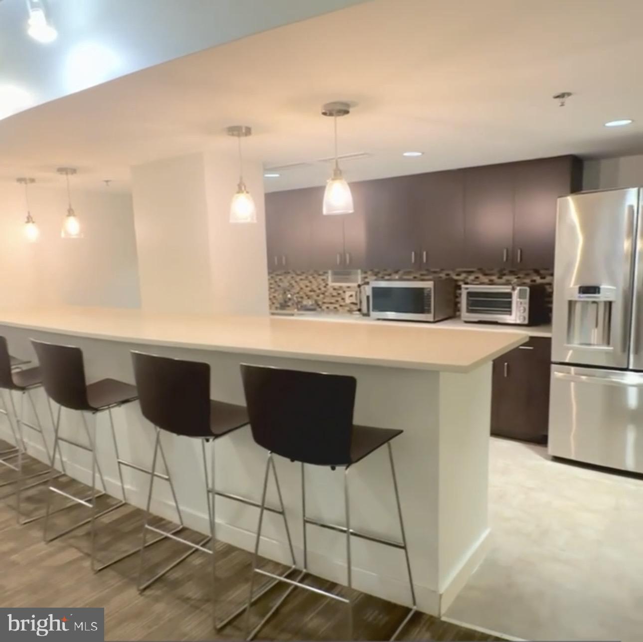 5101 River Road, Unit 1103 Bethesda, MD 20816 - Photo 22 of 22 a kitchen with stainless steel appliances kitchen island granite countertop a sink and cabinets