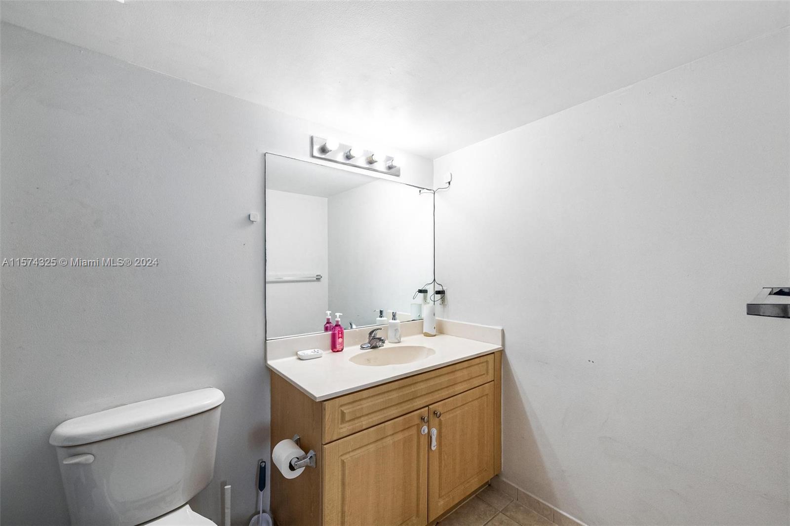 102 Southwest 6th Avenue, Unit 401 Miami, FL 33130 - Photo 17 of 27 a bathroom with a sink vanity mirror and toilet
