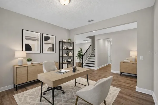 a view of an empty room with wooden floor and a ceiling fan