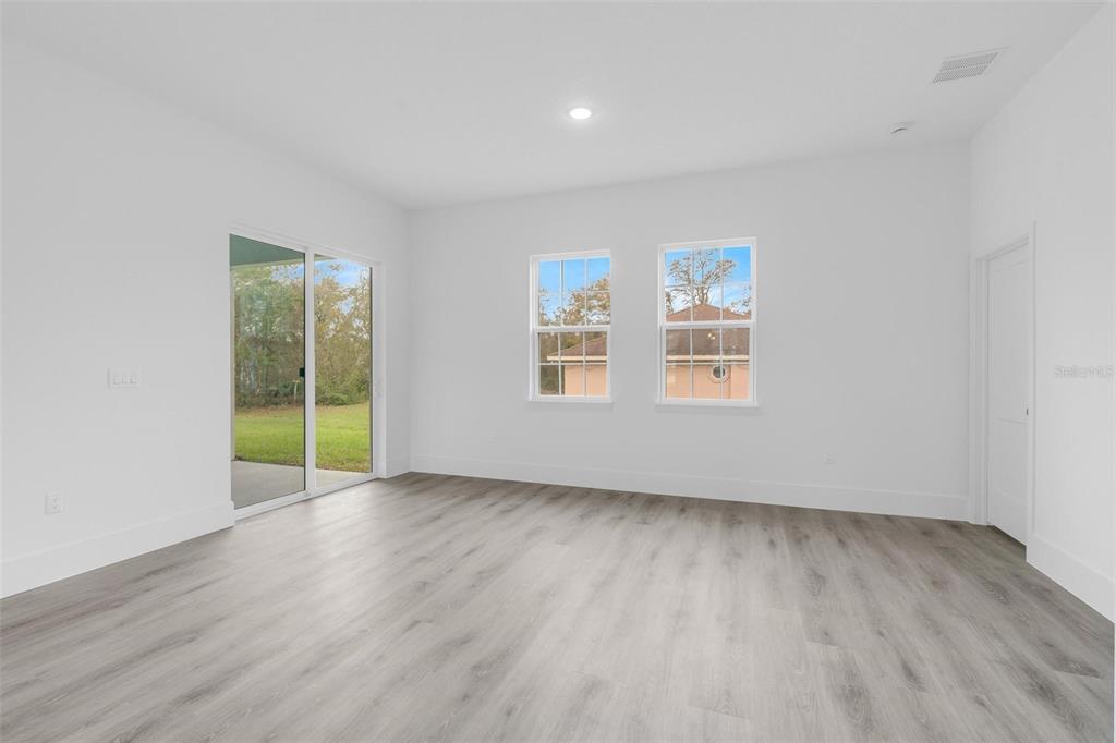 3172 Southwest 137th Loop Ocala, FL 34473 - Photo 12 of 38 an empty room with wooden floor and windows