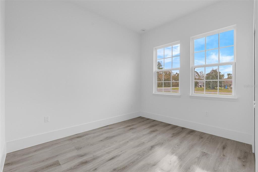 3172 Southwest 137th Loop Ocala, FL 34473 - Photo 15 of 38 an empty room with wooden floor and windows