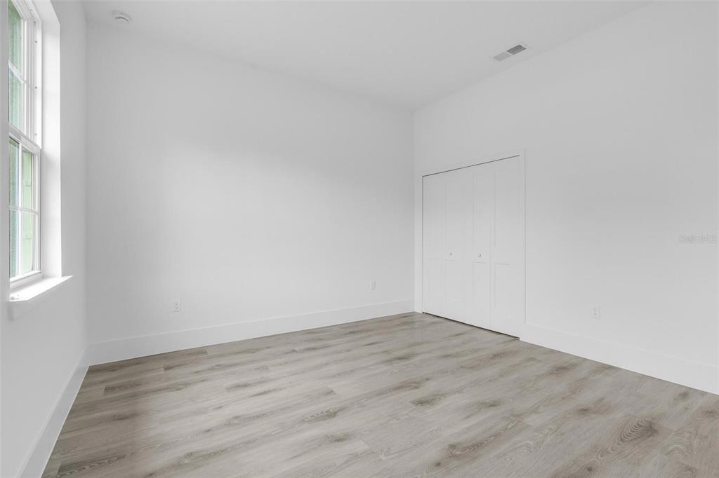3172 Southwest 137th Loop Ocala, FL 34473 - Photo 16 of 38 an empty room with wooden floor and windows