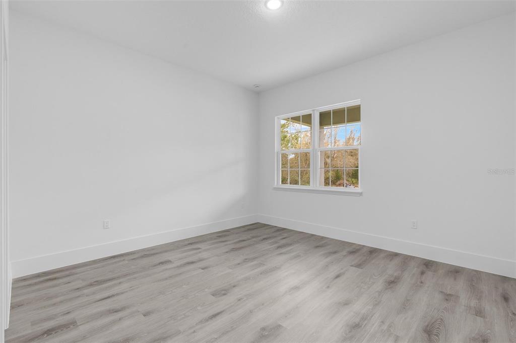 3172 Southwest 137th Loop Ocala, FL 34473 - Photo 20 of 38 an empty room with wooden floor and windows