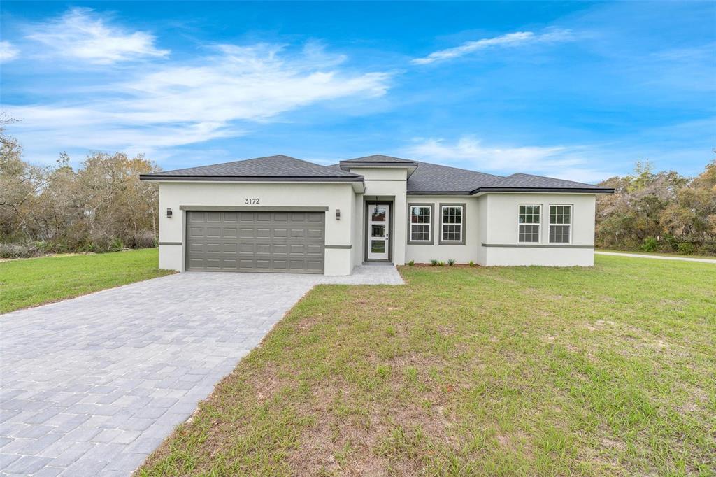 3172 Southwest 137th Loop Ocala, FL 34473 - Photo 2 of 38 front view of a house with a yard