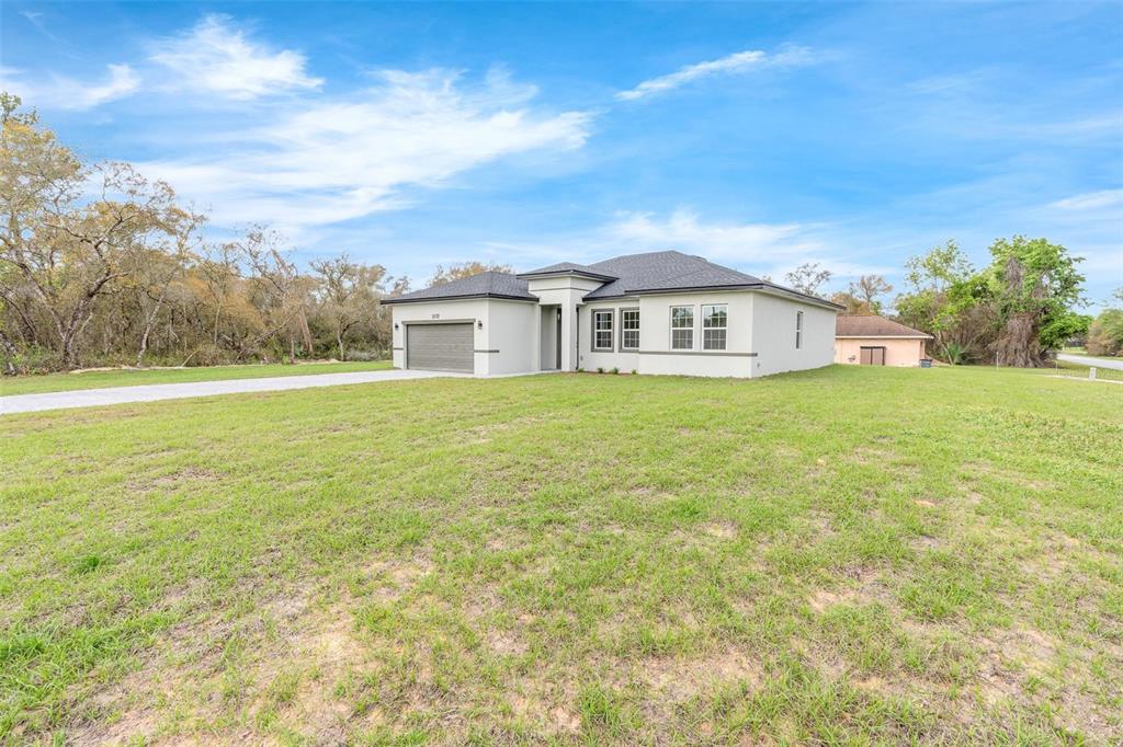 3172 Southwest 137th Loop Ocala, FL 34473 - Photo 31 of 38 a view of a house with a big yard and large trees