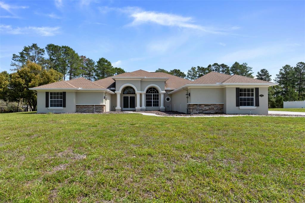 10130 Lazy Days Court Weeki Wachee, FL 34613 - Photo 2 of 85 a front view of a house with a garden