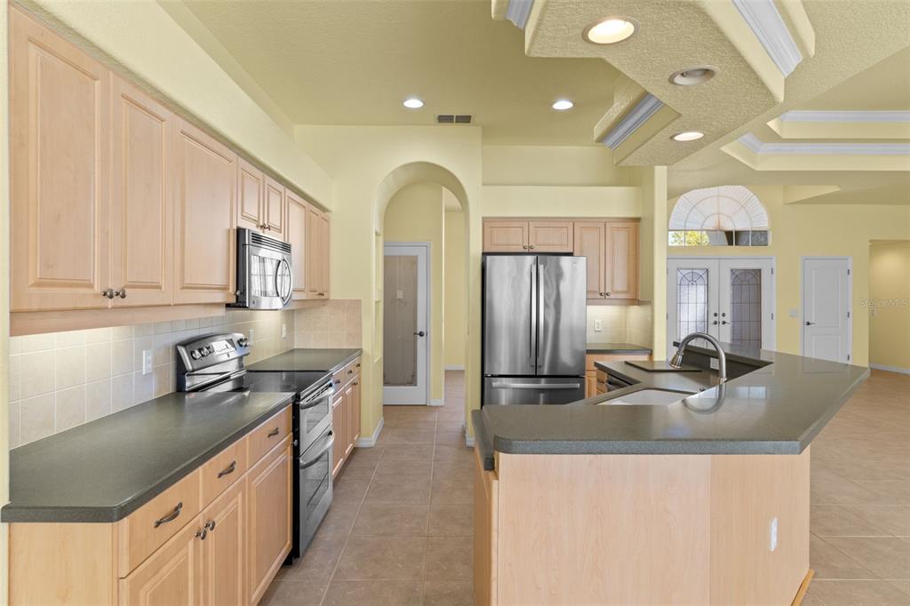 10130 Lazy Days Court Weeki Wachee, FL 34613 - Photo 22 of 85 a kitchen with stainless steel appliances granite countertop a sink a stove and a refrigerator