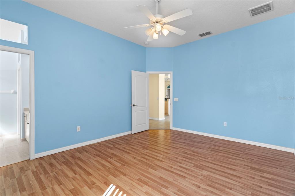 10130 Lazy Days Court Weeki Wachee, FL 34613 - Photo 49 of 85 wooden floor in an empty room with a chandelier fan