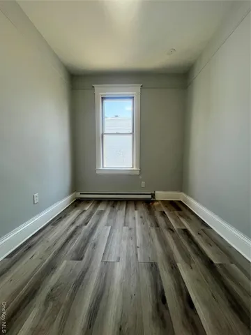a view of a room with wooden floor and window