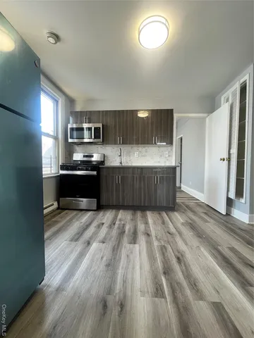a kitchen with wooden floors and stainless steel appliances