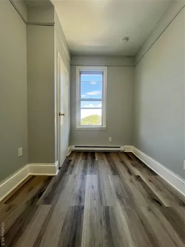 a view of a room with wooden floors and window