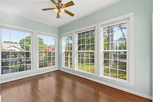 a view of an empty room with a window and wooden floor
